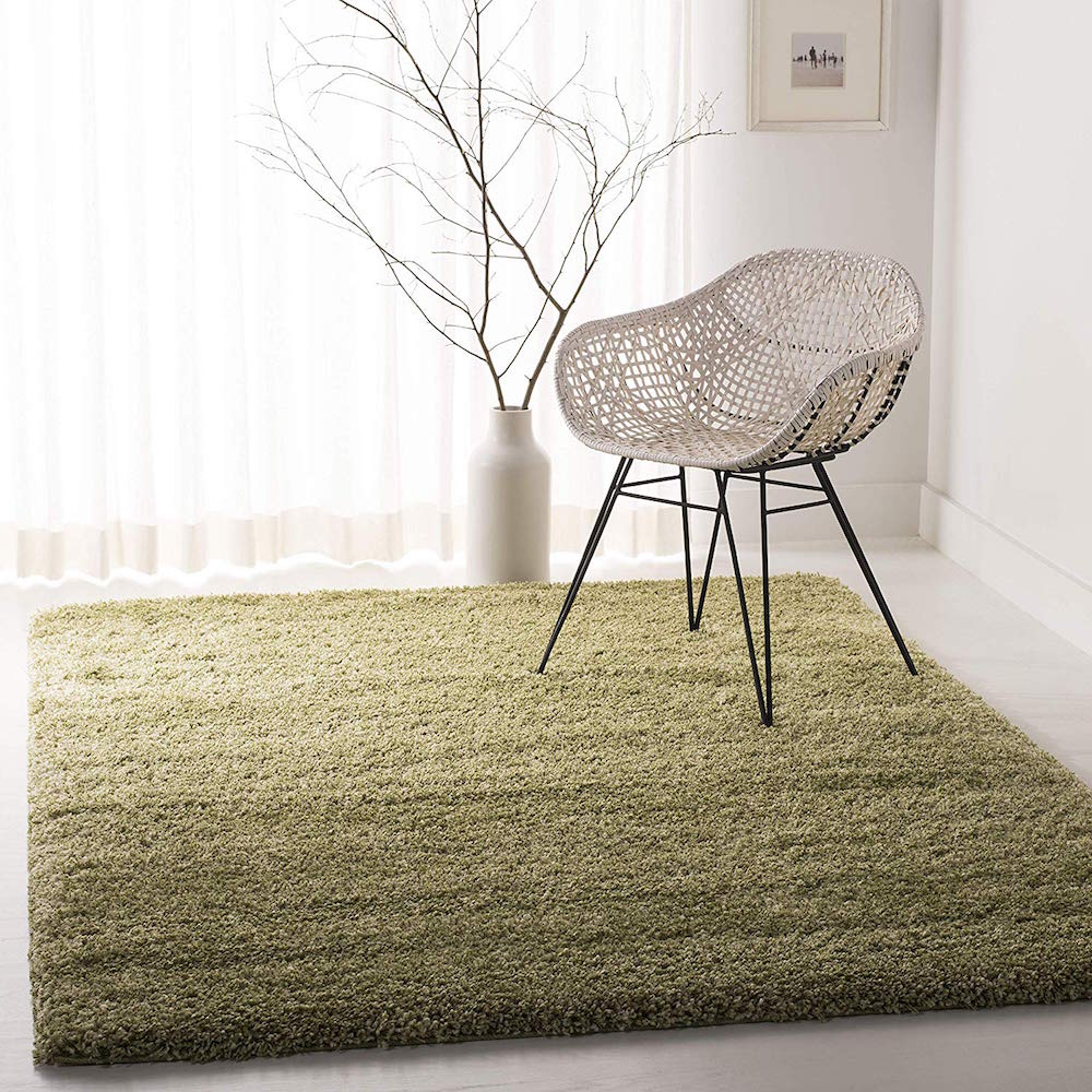 plush green rug with white chair and vase in white room