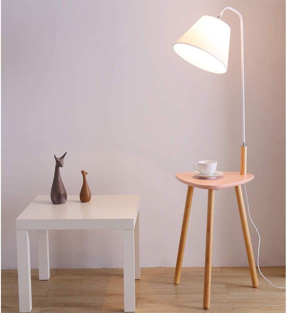 pink side table with lamp and white side table in pink room