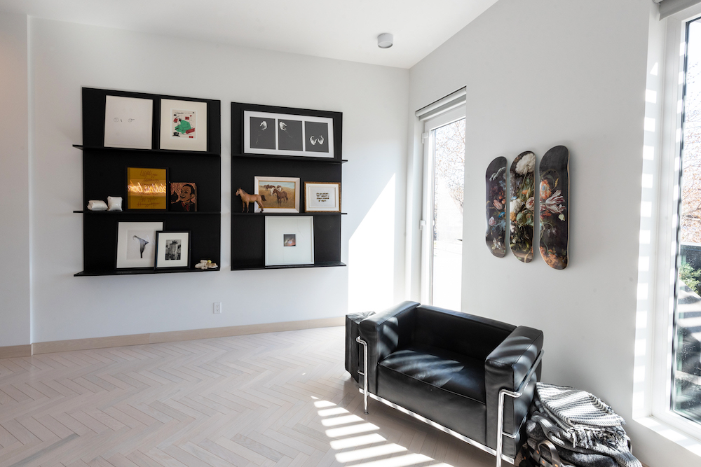 white room with black floating shelves and skateboards on wall