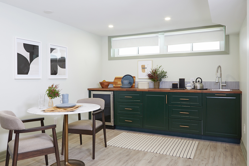 small kitchen area with forest-green lower cabinets and partial backsplash