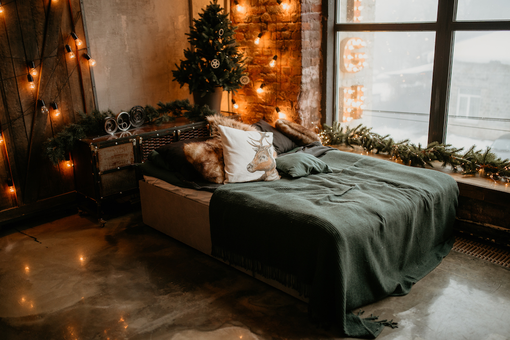 cozy bedroom with green bed, green garland and white lights