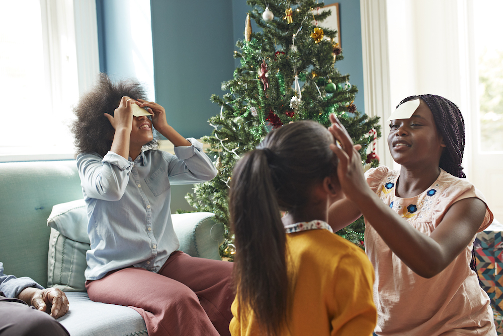 sisters playing holiday party games in blue living room at home