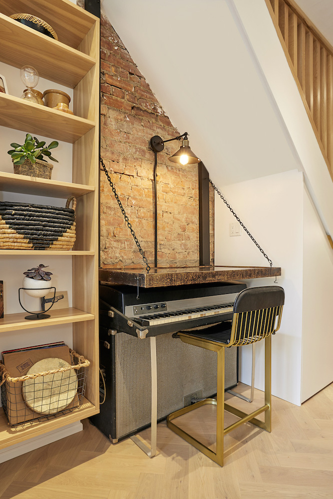 A small joint music nook and office space beneath the staircase in a small house