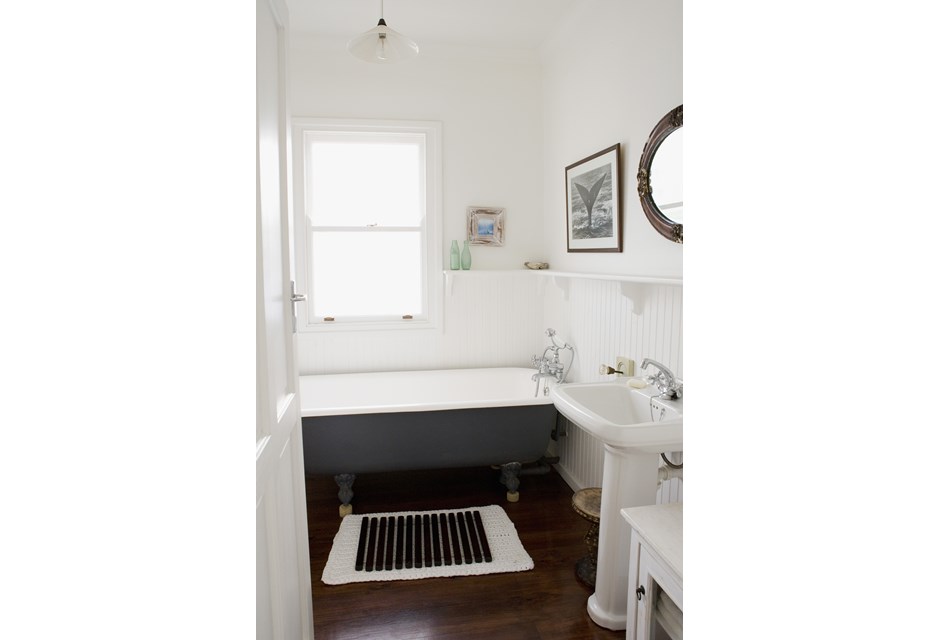 A grey and white soaker tub in a renovated cottage bathroom