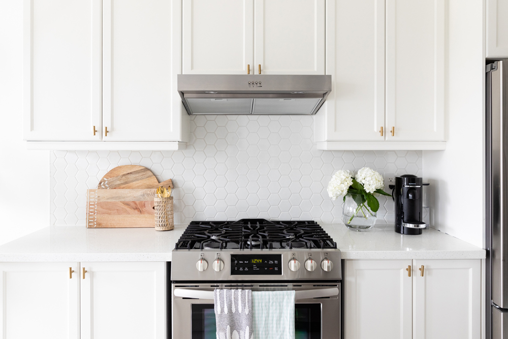 white kitchen with white hexagon tiles on backsplash