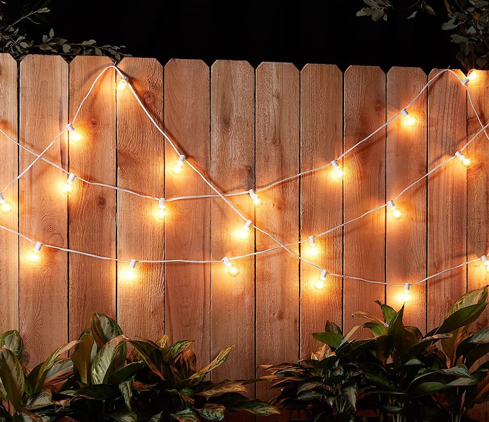 white string lights on wood fence at night