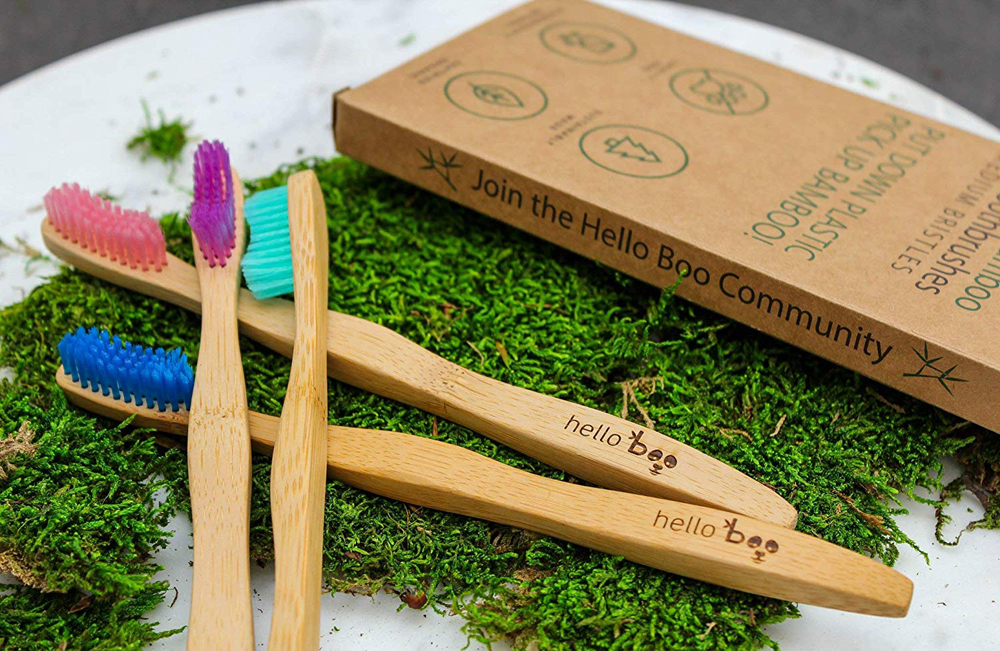 Bamboo toothbrushes laid out with its eco-friendly packaging