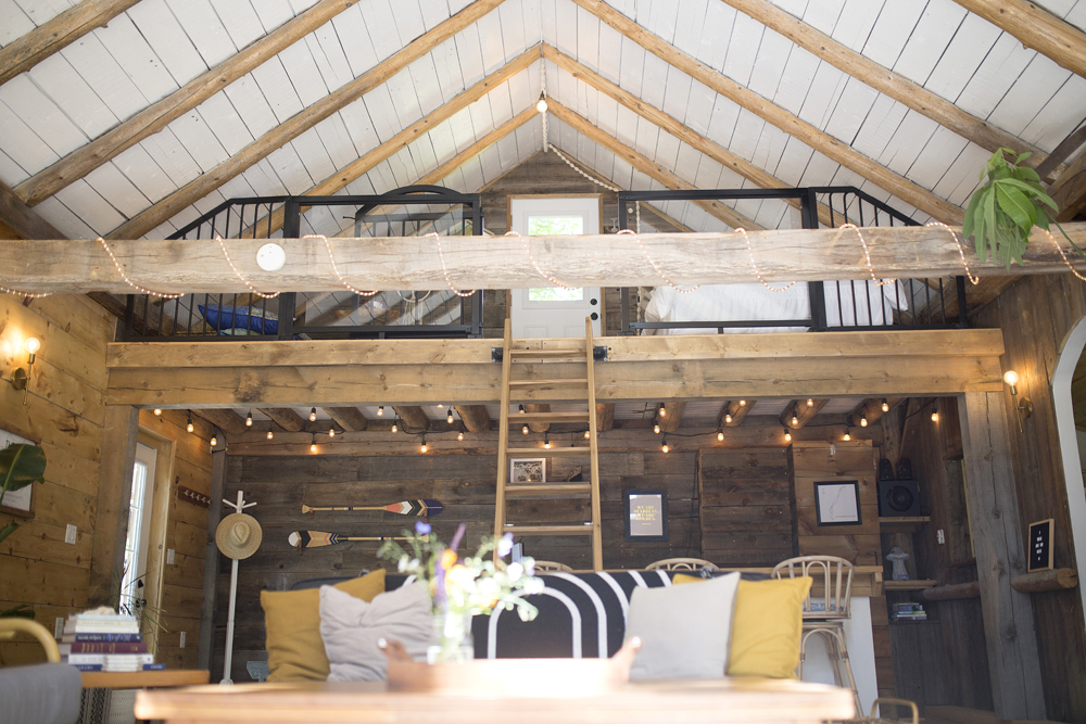 interior of converted barn with loft and white-washed vaulted ceiling