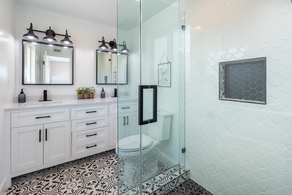 A modern bathroom with geometric floor and shower tiles