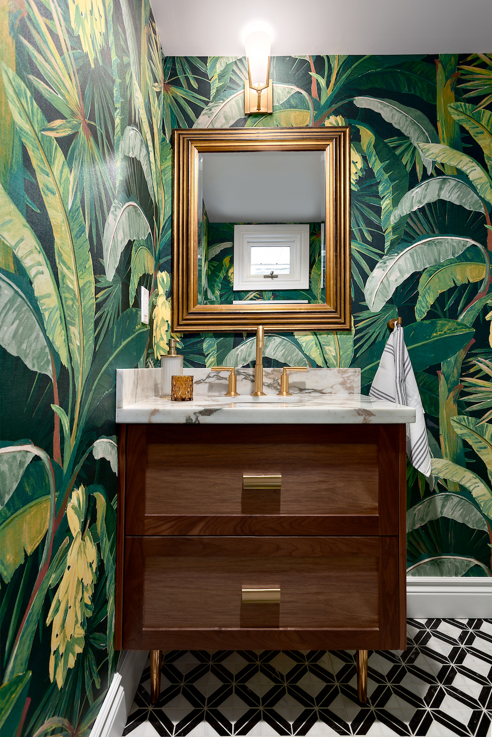 Tropical wallpaper in half bathroom with brass accents