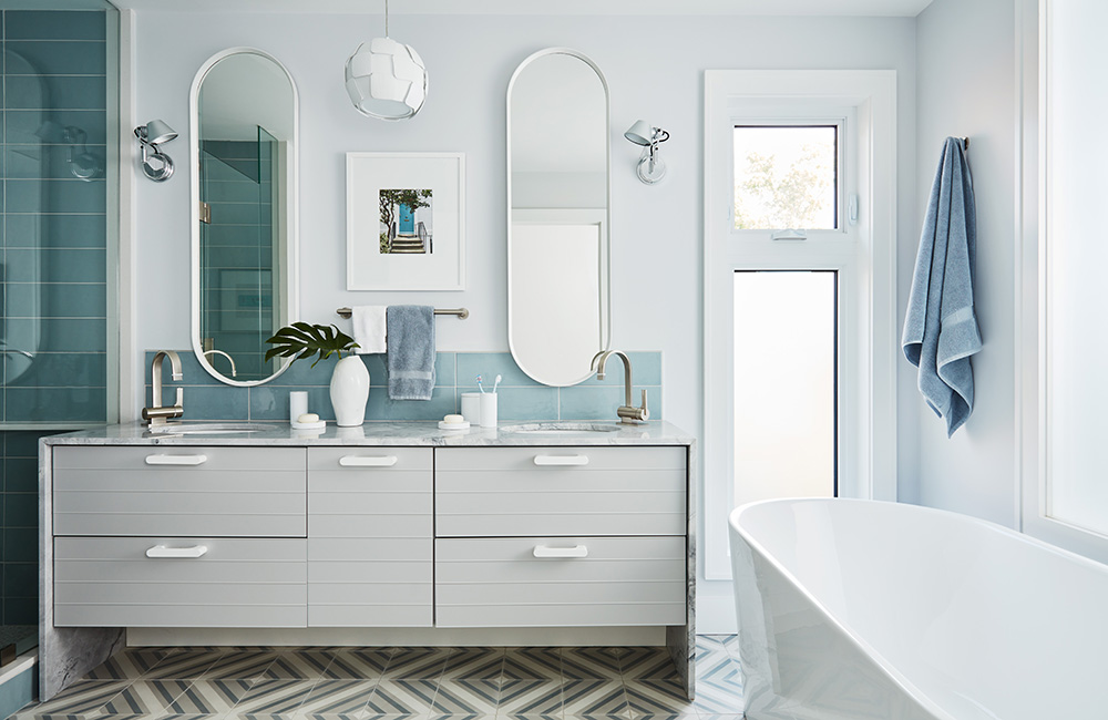 A soft blue minimalist bathroom design with a non-linear floor tile pattern