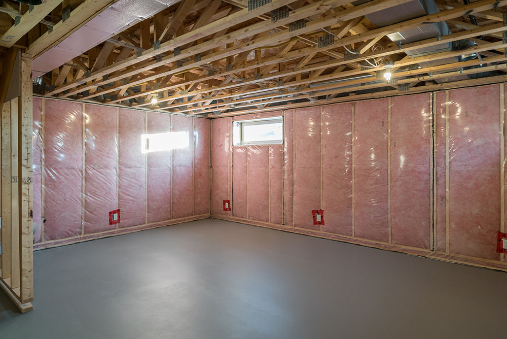 Empty basement with pink insulation on the walls