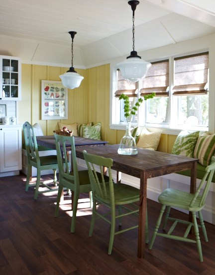 Pendant lights hanging over the kitchen table in a yellow and white cottage kitchen