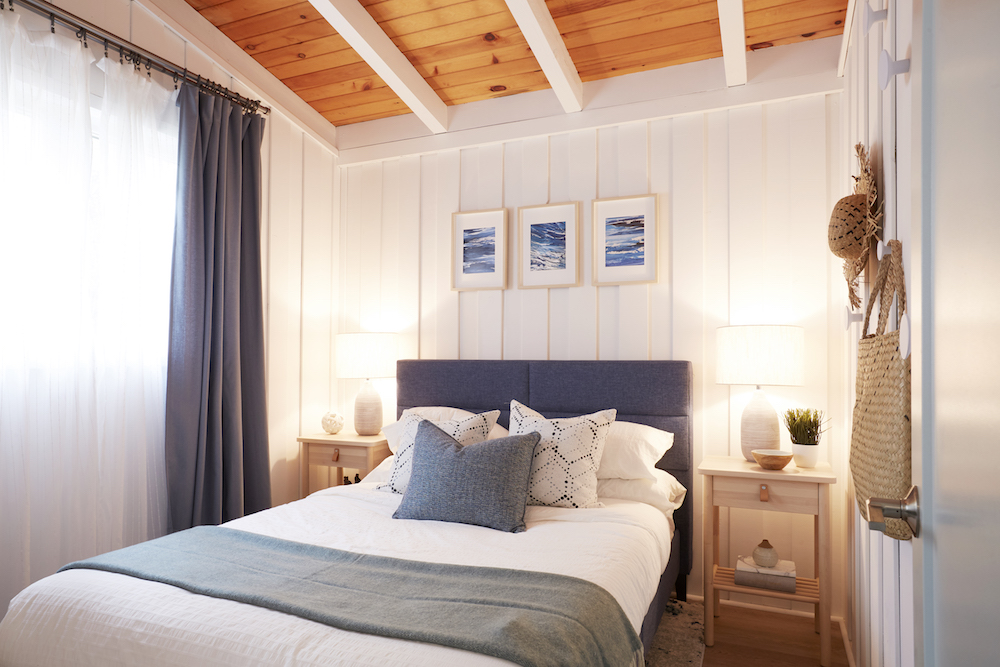 Coastal bedroom with white walls and grey headboard