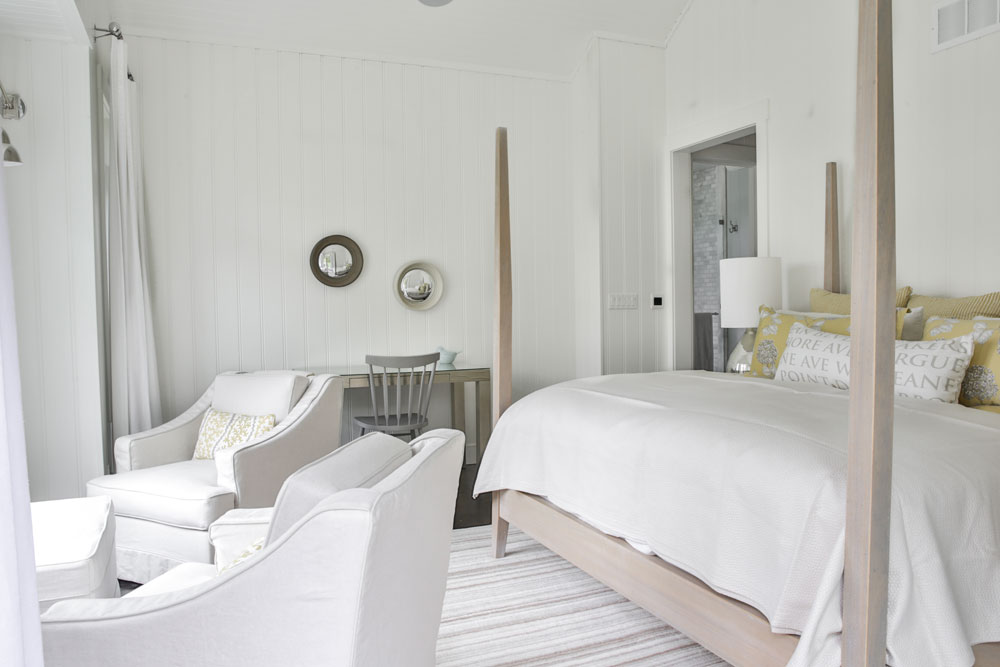 white bedroom with pale wood four poster bed