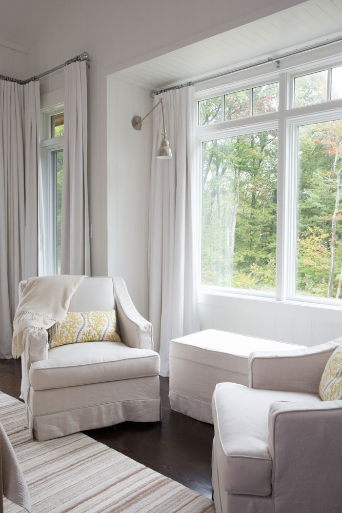 two cream slip covered chairs and ottoman in front of window