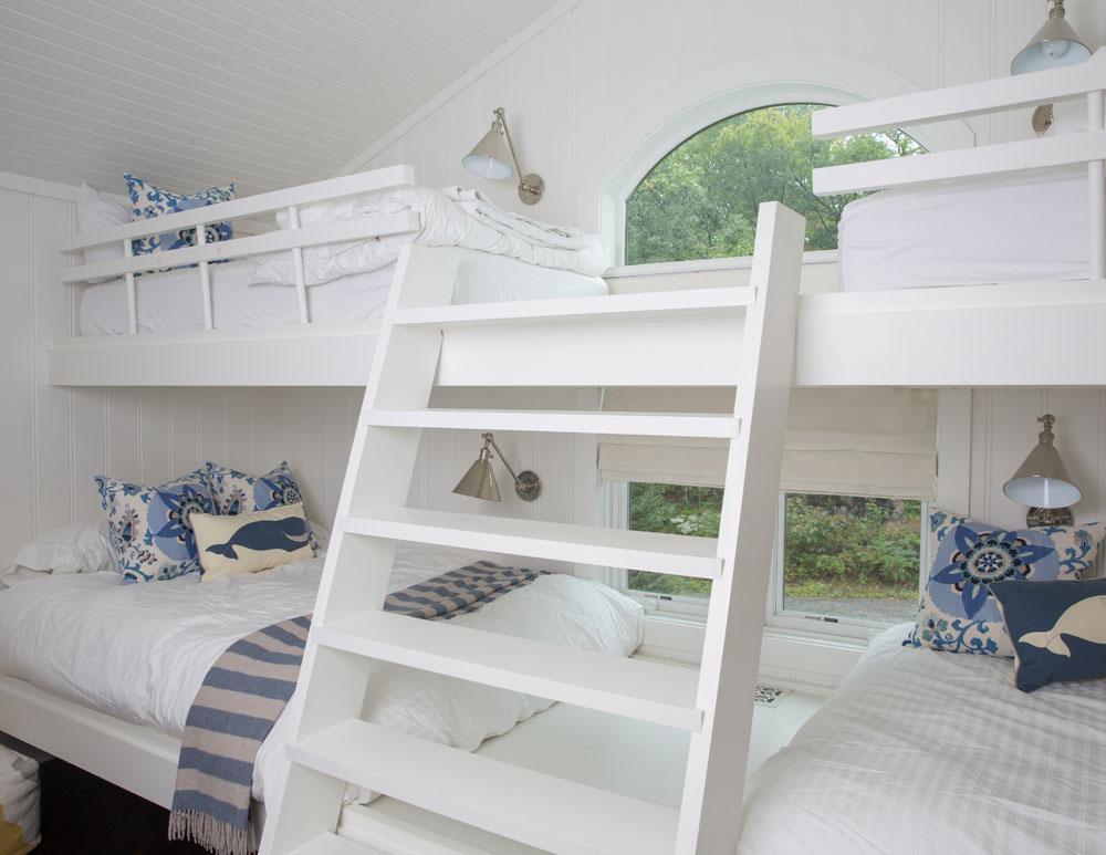 four white bunkbeds, window, ladder and blue and white cushions