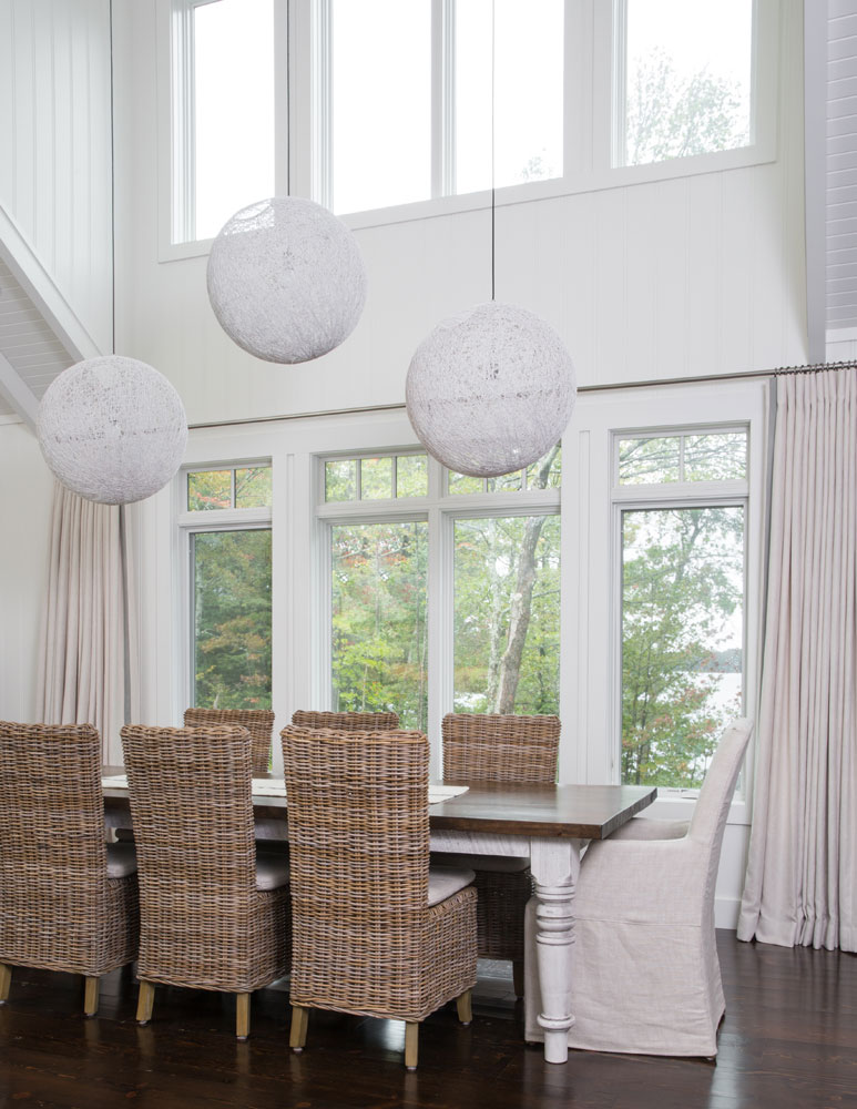 dining table beneath three white sphere pendant lights in double vaulted room