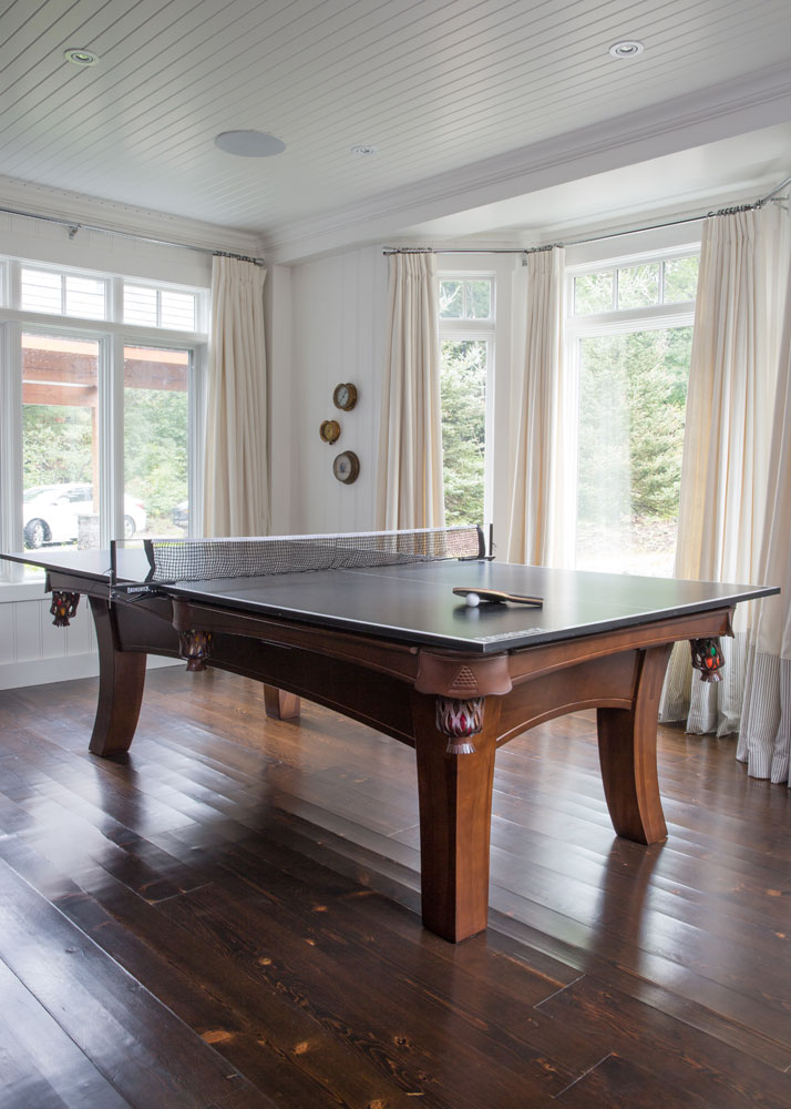 ping pong table on wood floors in room with cream curtains