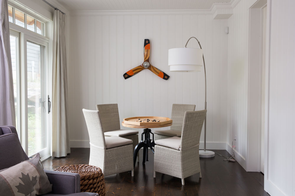 game table, four chairs, floor lamp and propeller on wall