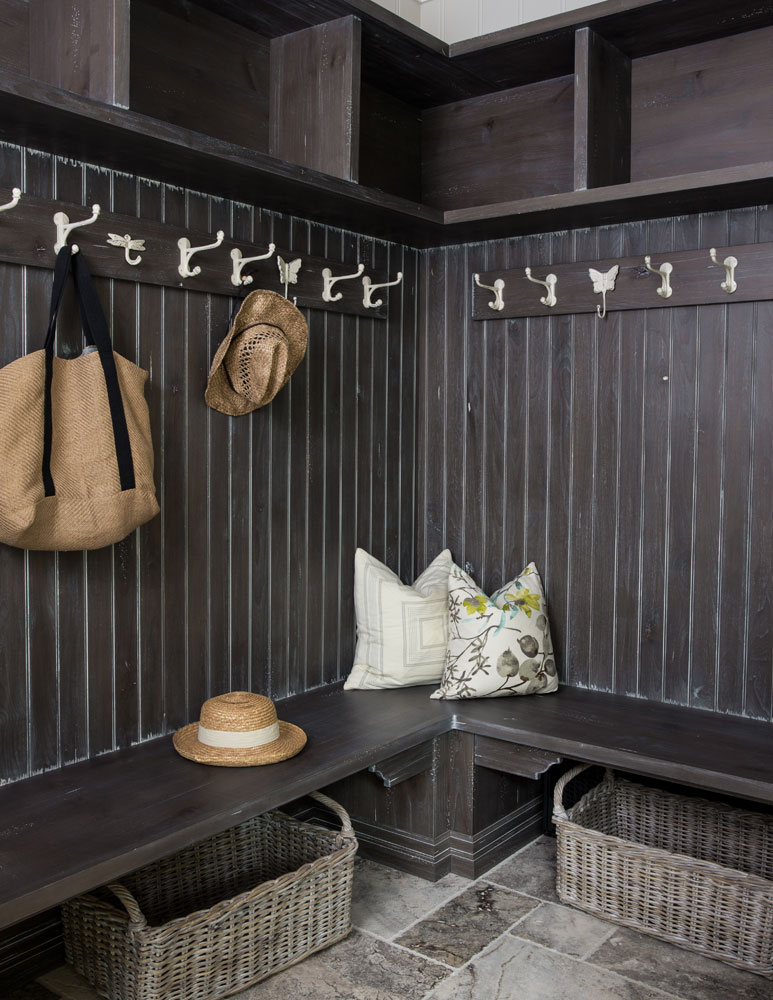 mudroom with grey wood walls and benches with two baskets beneath