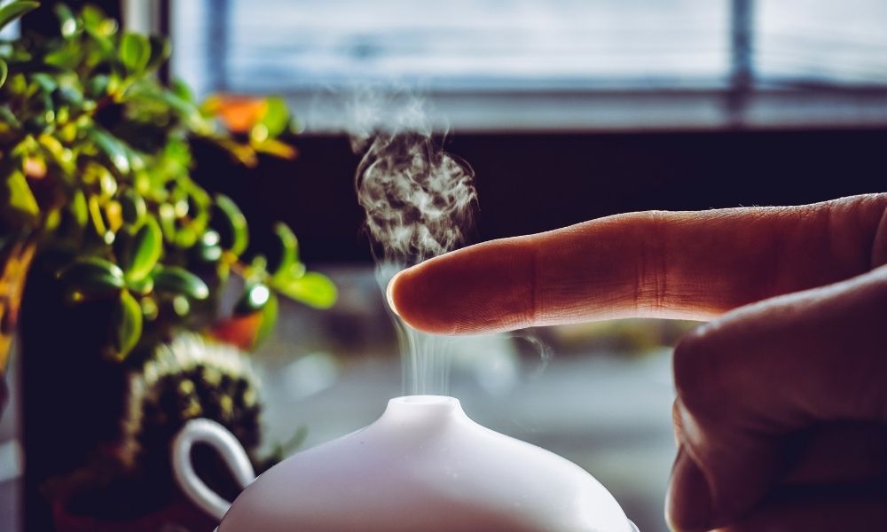 A finger obove the mist coming from a humidifier