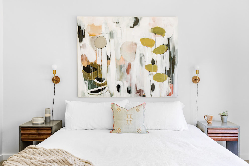 A large painted canvas hanging above the bed