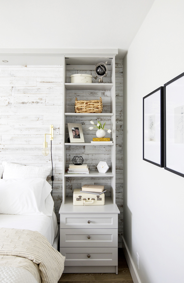 A tall, narrow wall unit next to a bed in a tight nook