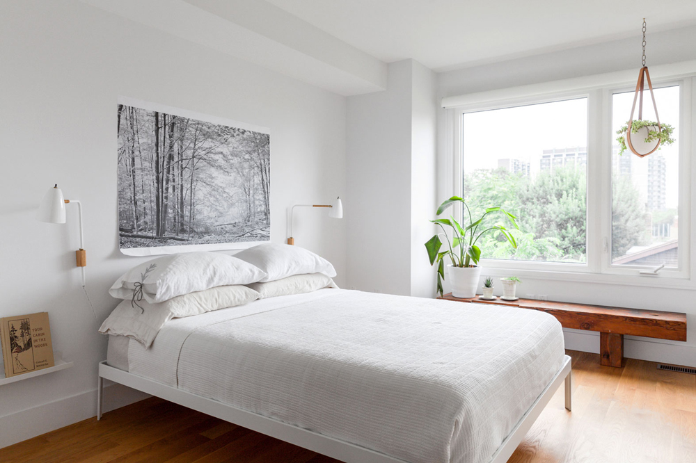 Sleek white bedroom with wood floors