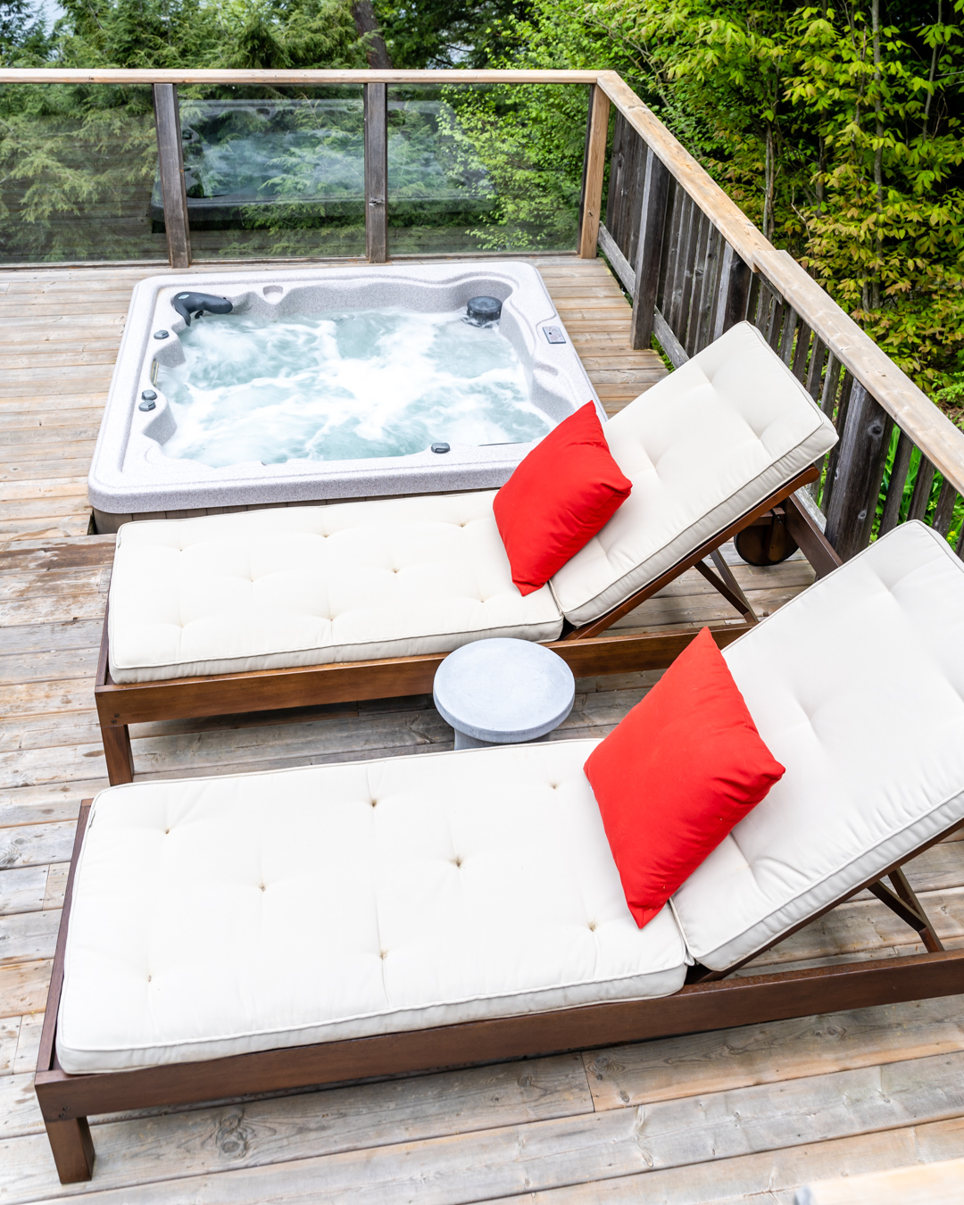 two loungers with red cushions by hot tub on deck