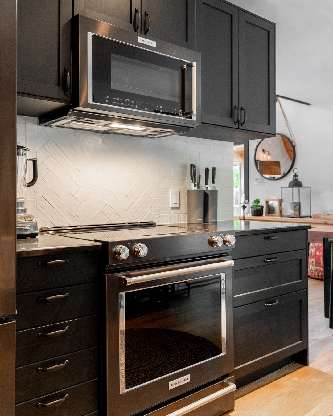 black kitchen cabinetry, Kitchenaid stove and microwave above