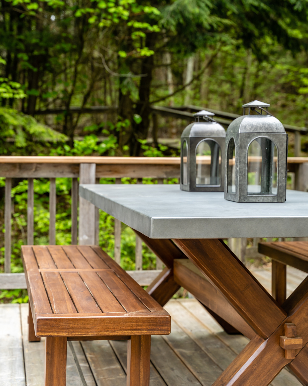 two grey metal lanterns on picnic style table