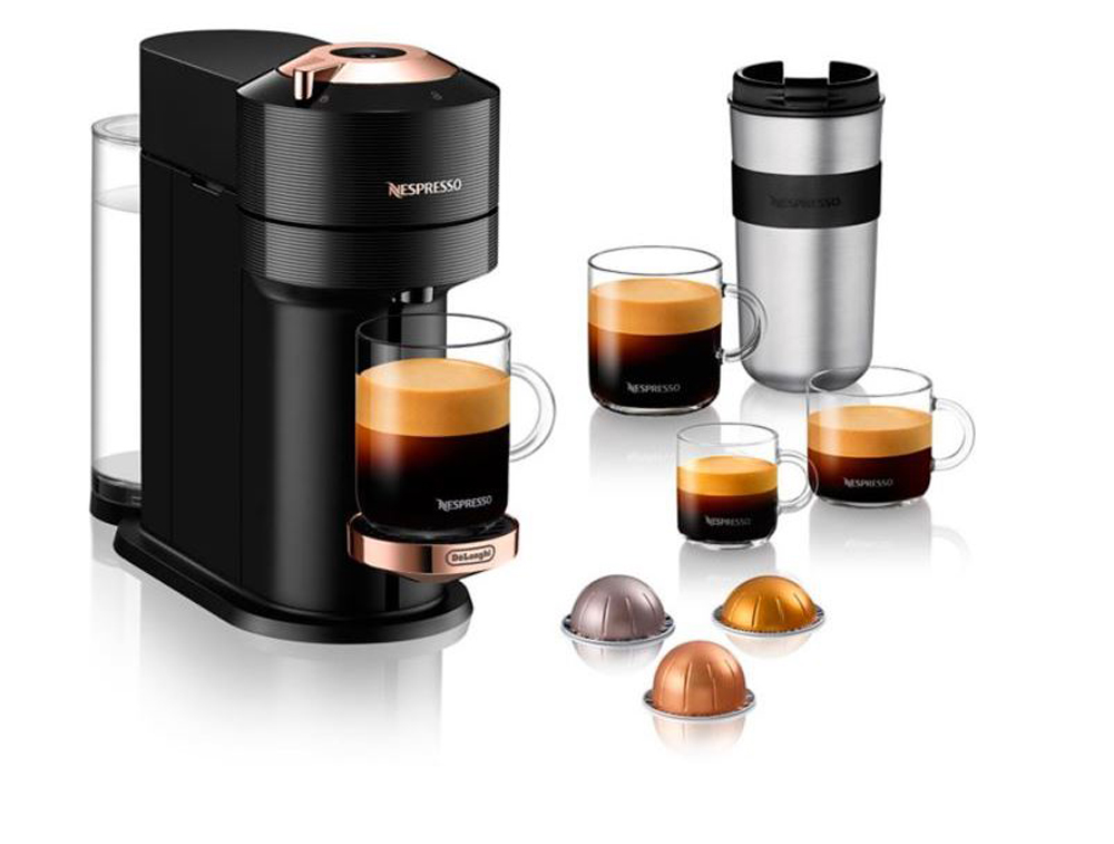 A Nespresso coffee maker surrounded by a mug and coffee pods