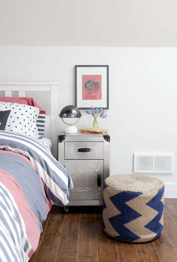 bedroom with silver side table as focus and burlap stool with blue chevron stripes