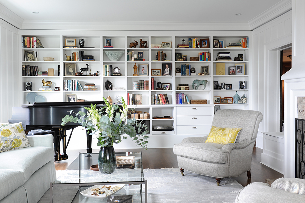 Modern-meets-traditional living room with wall of shelving and books.