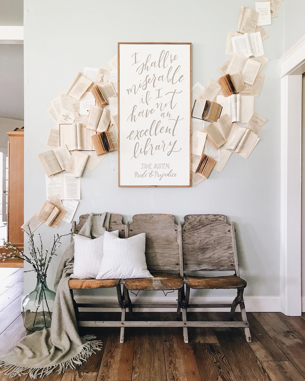 A DIY creation featuring a framed photo of a book surrounded by a flurry of open books and torn pages that climb up the wall