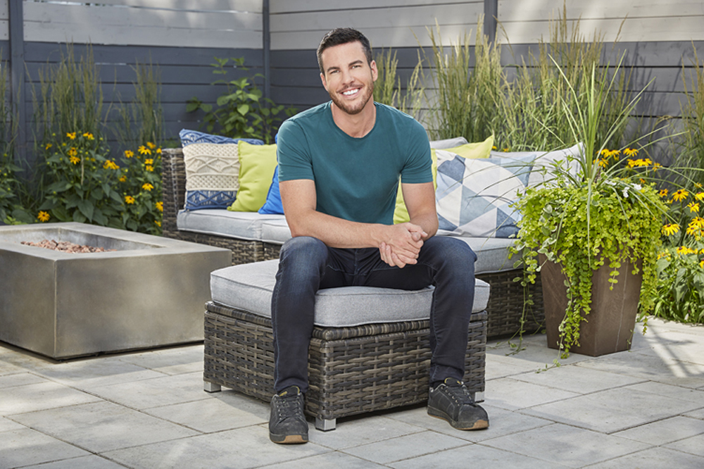Brian McCourt sitting on patio furniture in newly renovated backyard
