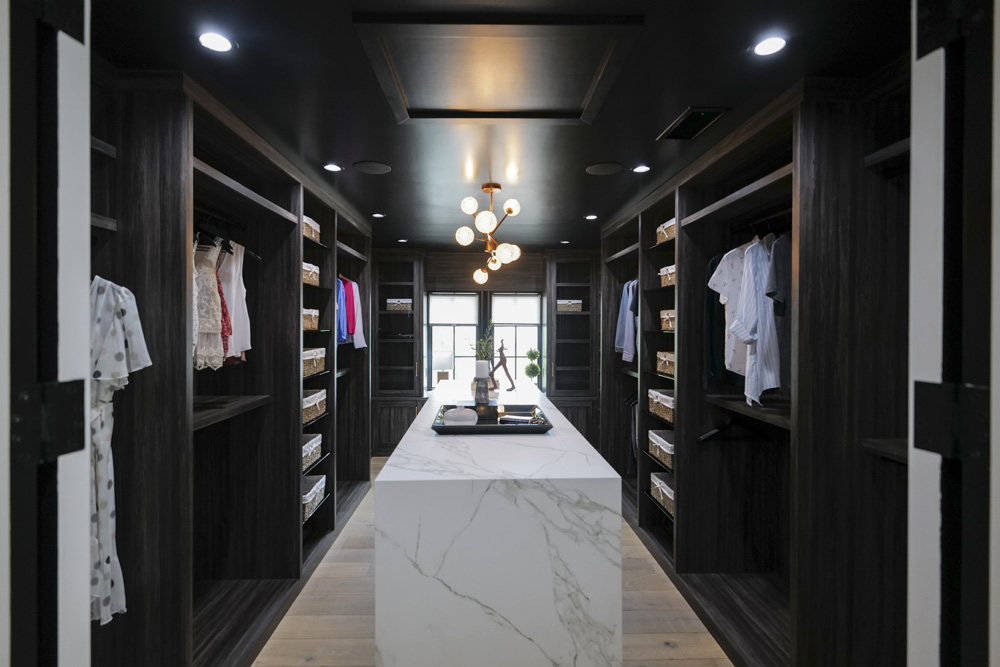 The window at the far end of this renovated walk-in closet feeds plenty of natural light into this otherwise dark and sophisticated interior