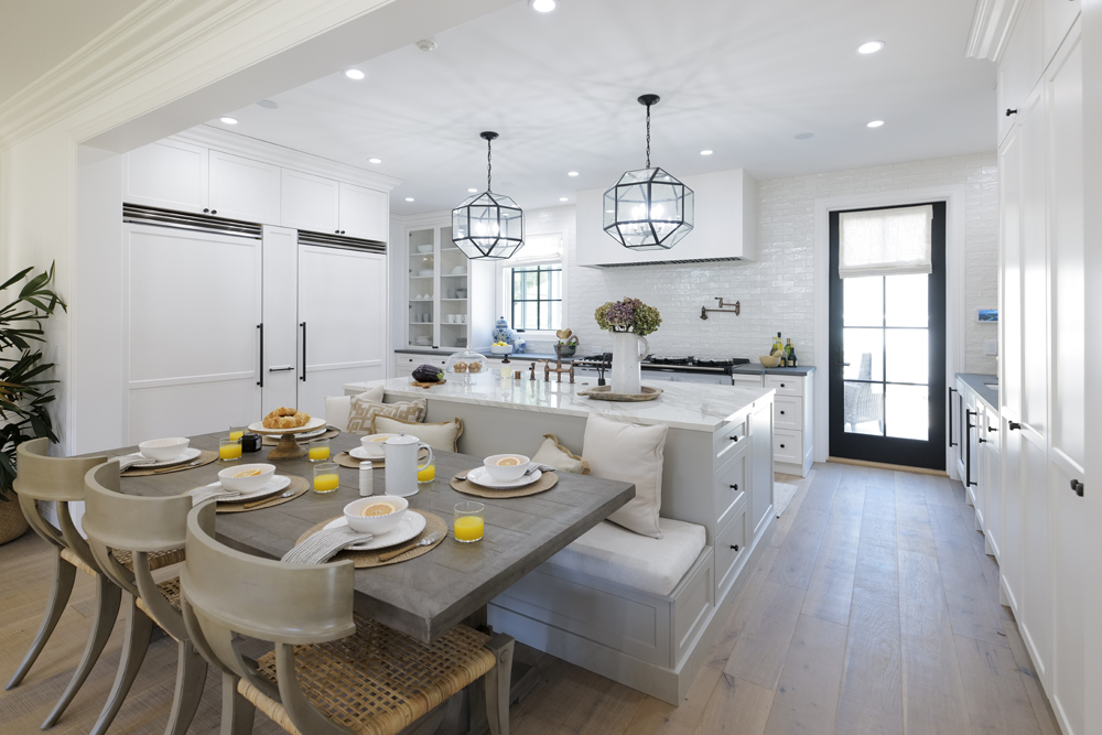 A breakfast nook behind a kitchen island in a small renovated kitchen in a historic mansion