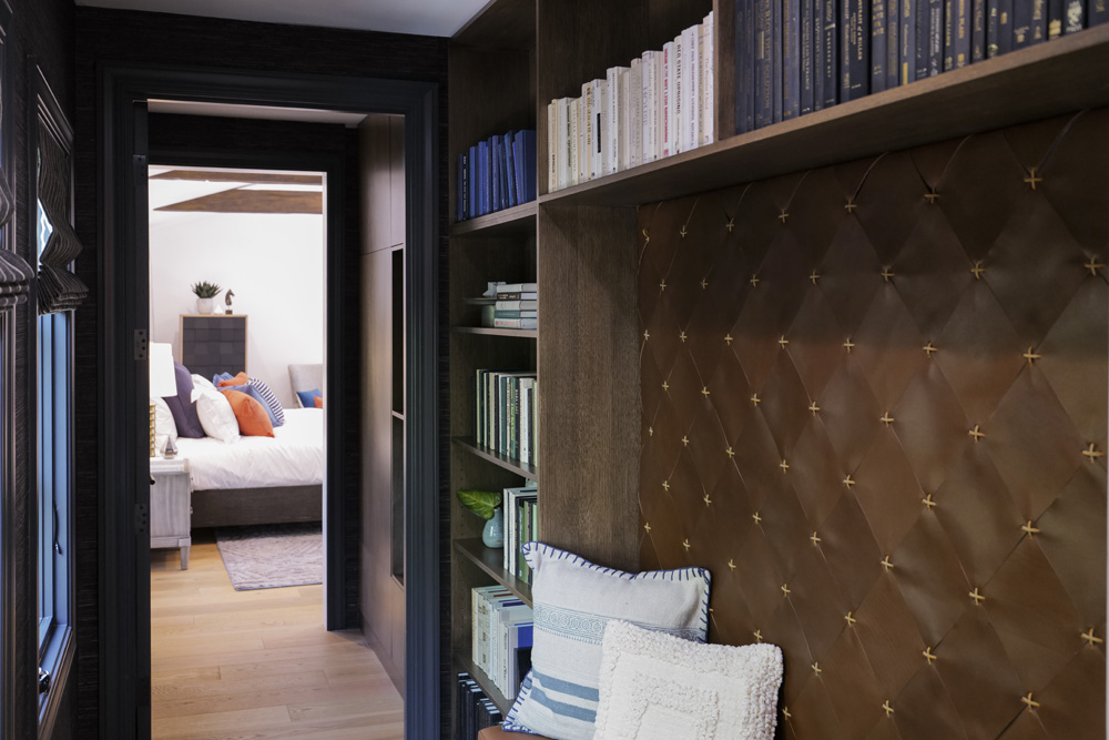 A narrow hallway that leads to the bedroom completely redesigned as a dark and moody home library