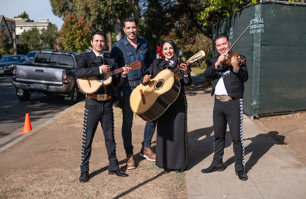 Jonathan Scott poses outside with a three-member mariachi band