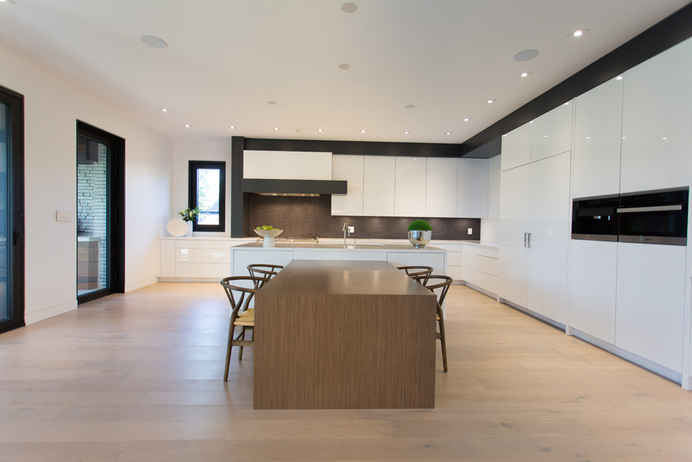Modern white kitchen with hardwood flooring.