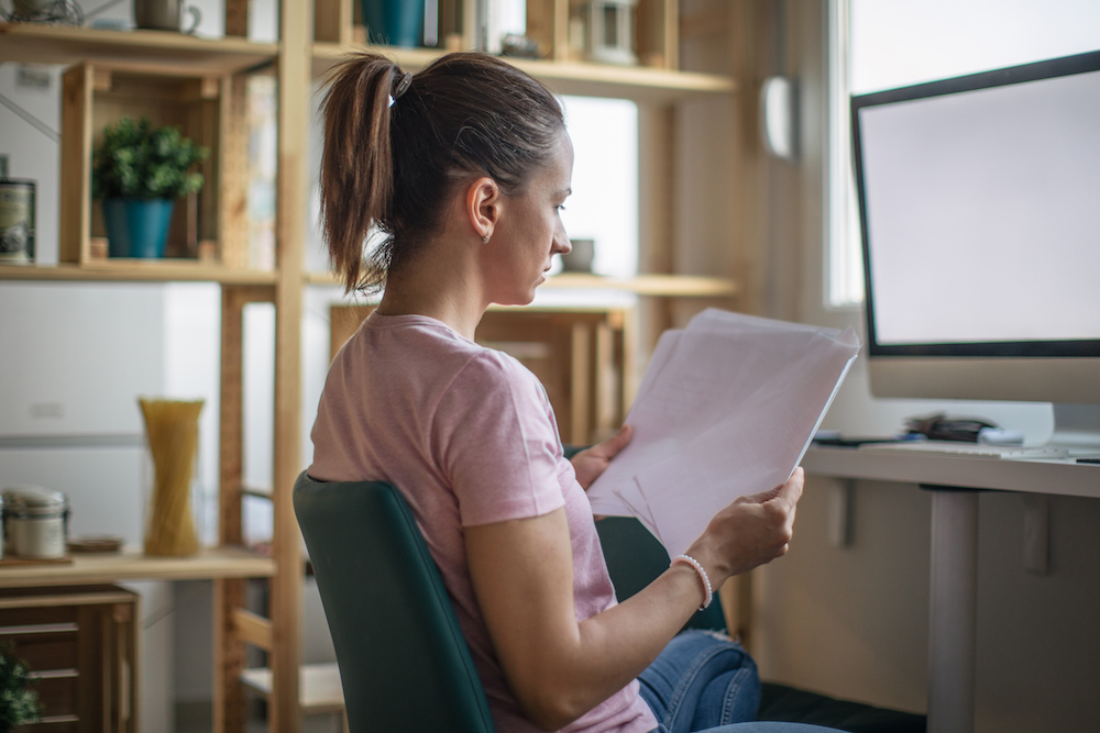 woman sorting papers while sitting at desk