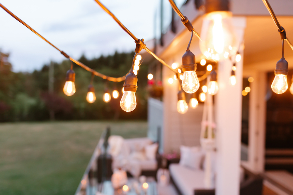 String lights hanging above a decorated backyard table