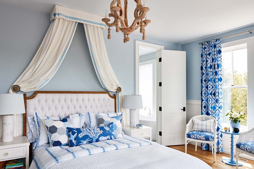 A beachy blue and white bedroom with an elegant mini canopy