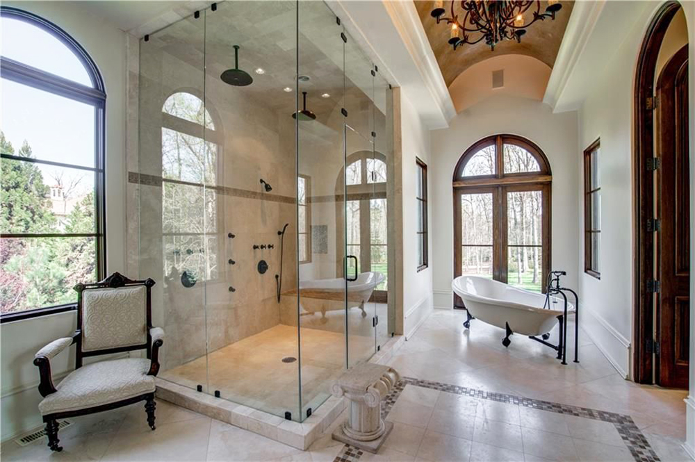 A pristine ensuite master bathroom with a standing shower and separate claw-foot tub