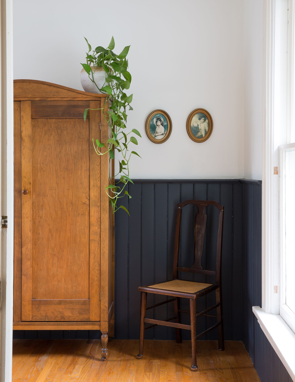 A vintage armoire and chair in the midnight blue bathroom