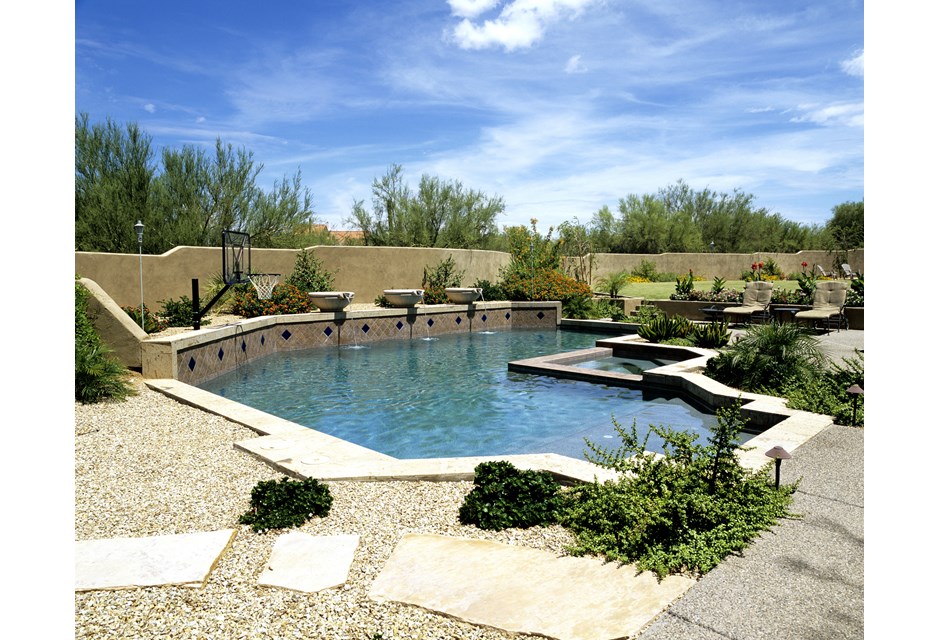 Backyard pool surrounded by stone and rocks