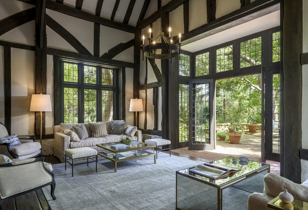 A Tudor-style sitting room facing the back patio which also features of wooded area