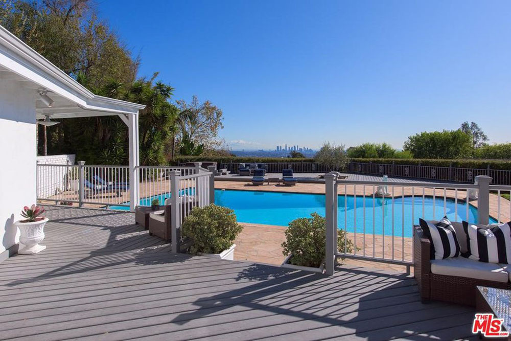 A gorgeous backyard with large swimming pool and views overlooking the city of Los Angeles
